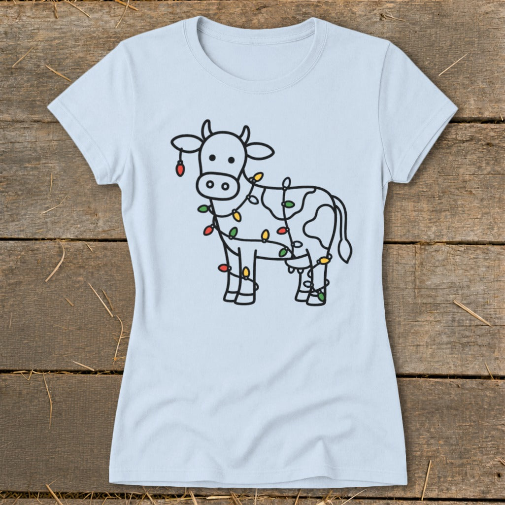 Light blue t-shirt with a line drawing of a cow wrapped in colorful Christmas lights.