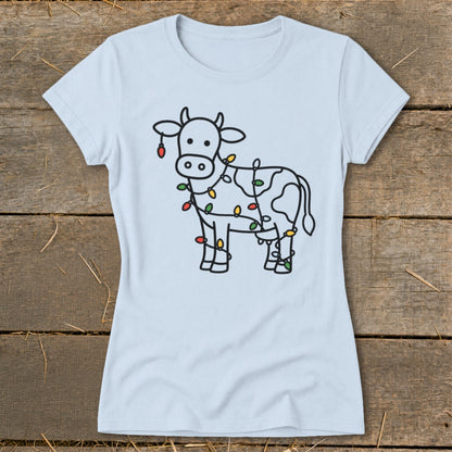 Light blue t-shirt with a line drawing of a cow wrapped in colorful Christmas lights.