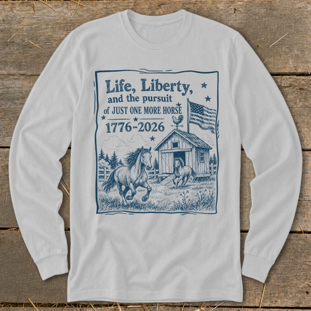 White long sleeve shirt with graphic: "Life, Liberty, and the pursuit of JUST ONE MORE HORSE 1776-2026" and horses.