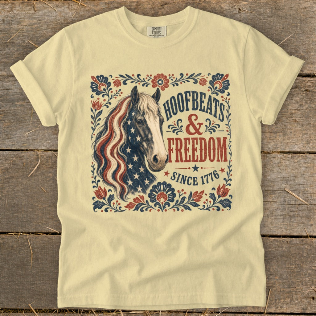 Pale yellow t-shirt with horse graphic and text "Hoofbeats & Freedom Since 1776".