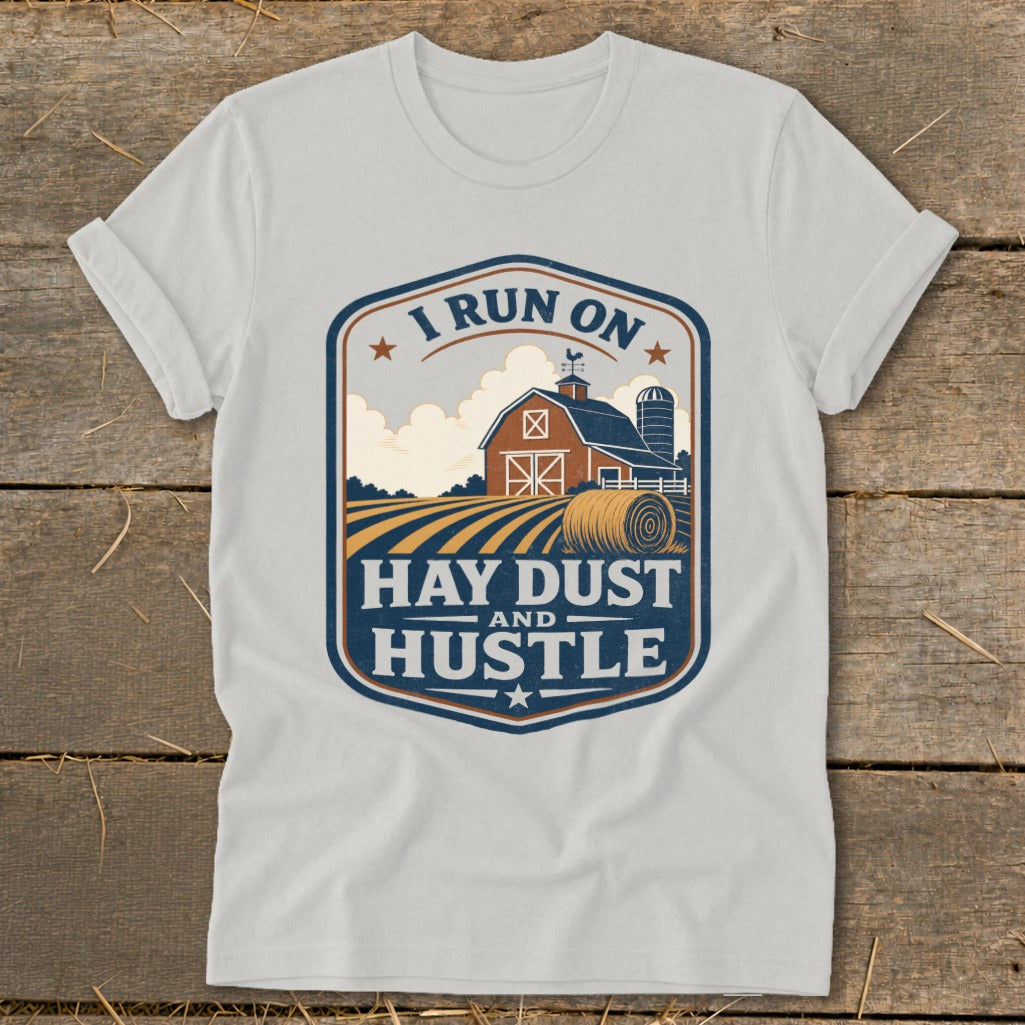 T-shirt graphic with barn, hay bale, and text "I run on hay dust and hustle".