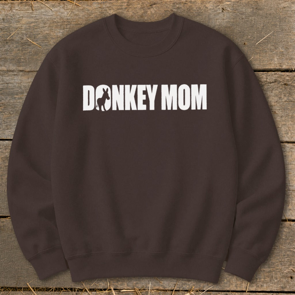 A dark brown crewneck sweatshirt featuring white text that reads "DONKEY MOM" with a donkey silhouette inside the first letter O.