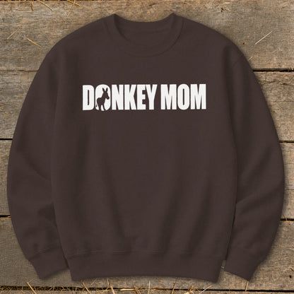 A dark brown crewneck sweatshirt featuring white text that reads "DONKEY MOM" with a donkey silhouette inside the first letter O.