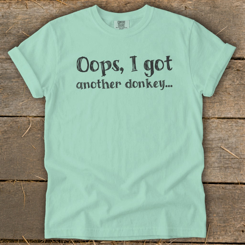 Mint green t-shirt with black text that reads "Oops, I got another donkey..."