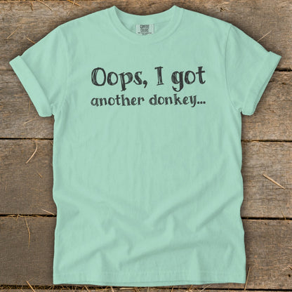 Mint green t-shirt with black text that reads "Oops, I got another donkey..."