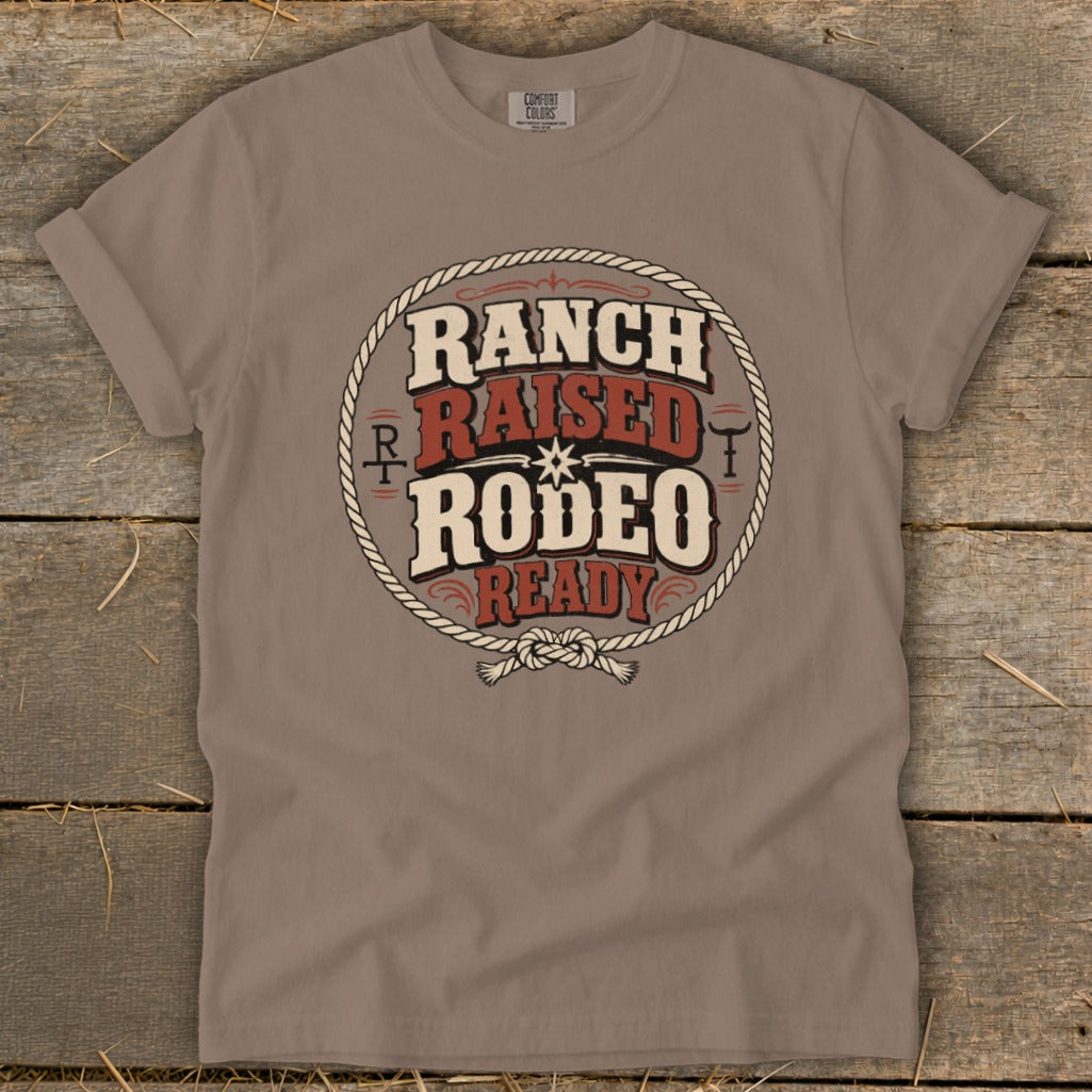 Taupe t-shirt featuring a circular western graphic with the text Ranch Raised Rodeo Ready.