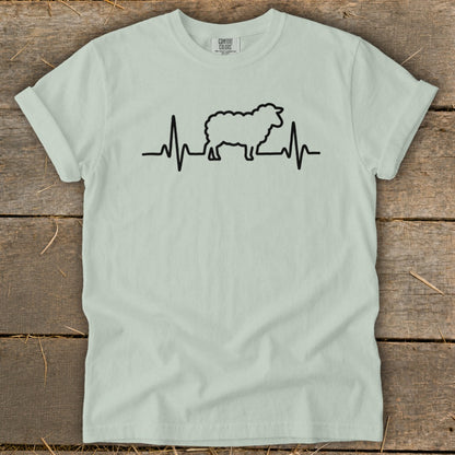 Light green short-sleeve t-shirt with a black graphic of a sheep integrated into a heartbeat line.