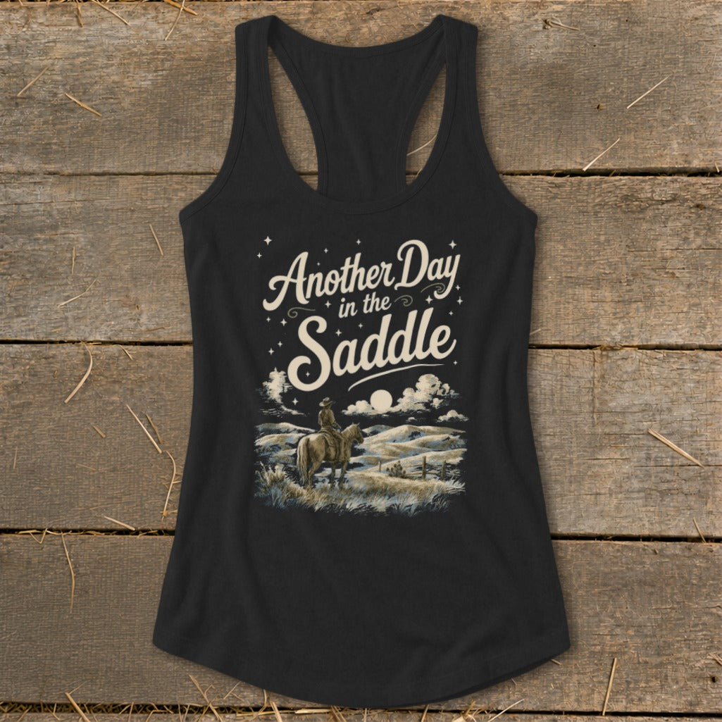 Black tank top with "Another Day in the Saddle" text and cowboy on horseback graphic.