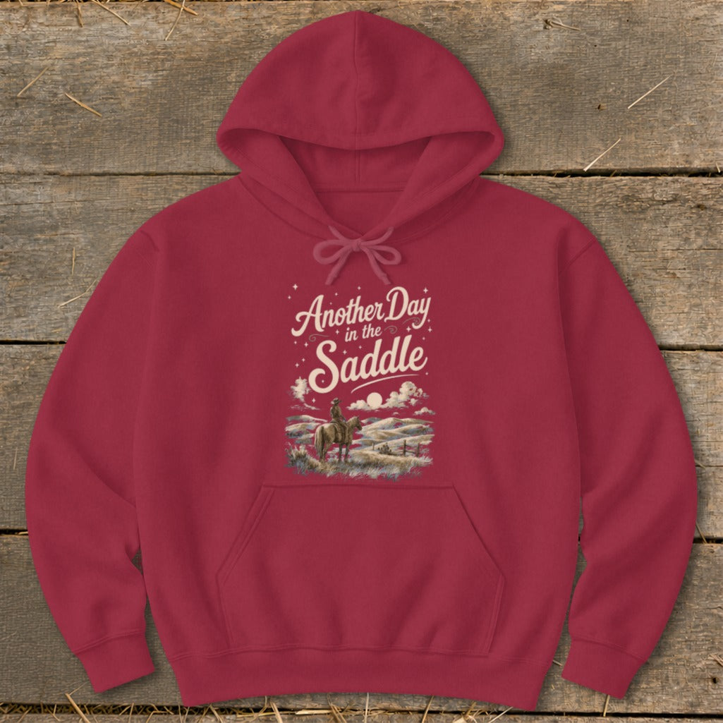 Crimson hoodie with "Another Day in the Saddle" text and cowboy on horseback graphic.