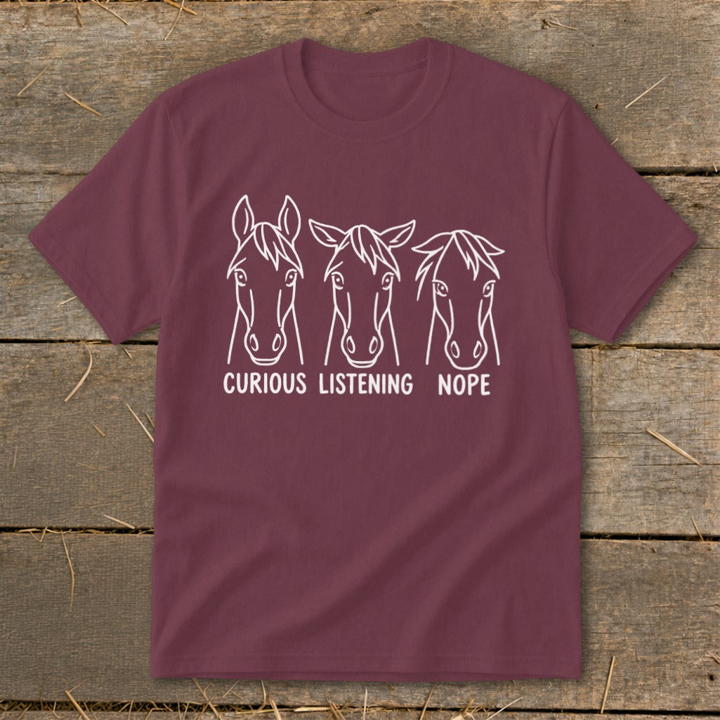 Maroon t-shirt featuring three horse heads with different ear positions labeled Curious, Listening, and Nope.