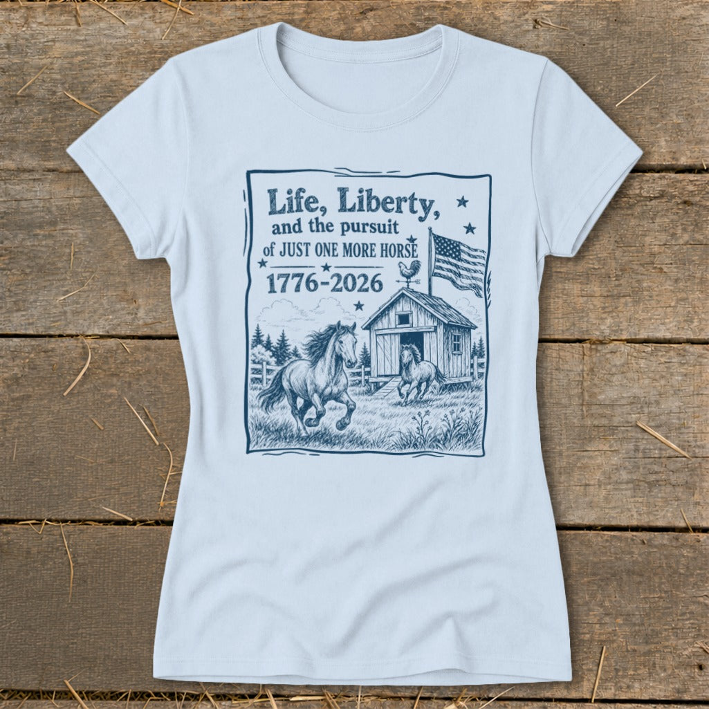 Light blue t-shirt with graphic: "Life, Liberty, and the pursuit of JUST ONE MORE HORSE 1776-2026" and horses.