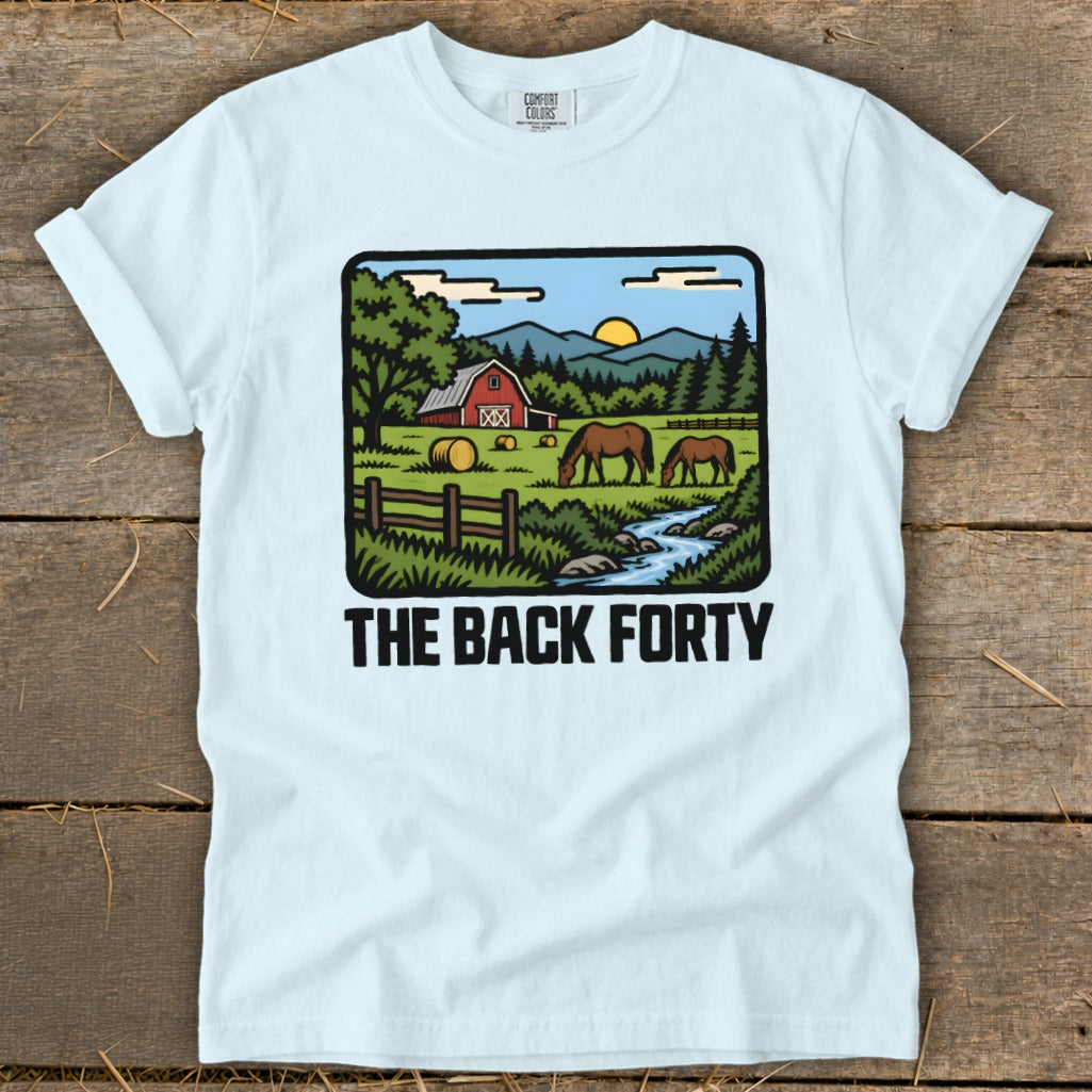 Light blue t-shirt featuring a pastoral landscape illustration with horses, a red barn, and the text The Back Forty.