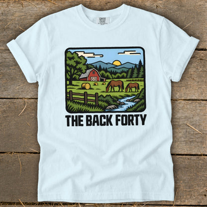 Light blue t-shirt featuring a pastoral landscape illustration with horses, a red barn, and the text The Back Forty.