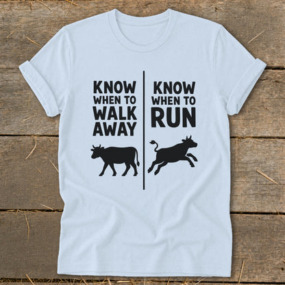Light blue t-shirt with text "KNOW WHEN TO WALK AWAY" and "KNOW WHEN TO RUN" with cows.