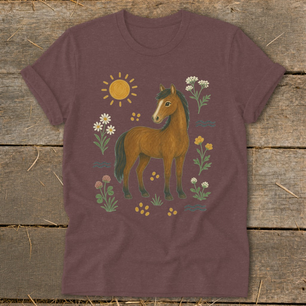 Brown horse with flowers, sun, and wavy lines on a maroon t-shirt.