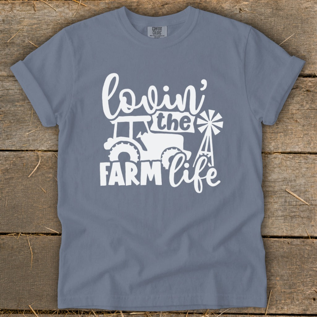 Blue t-shirt with white graphic text "lovin' the farm life" and farm imagery.