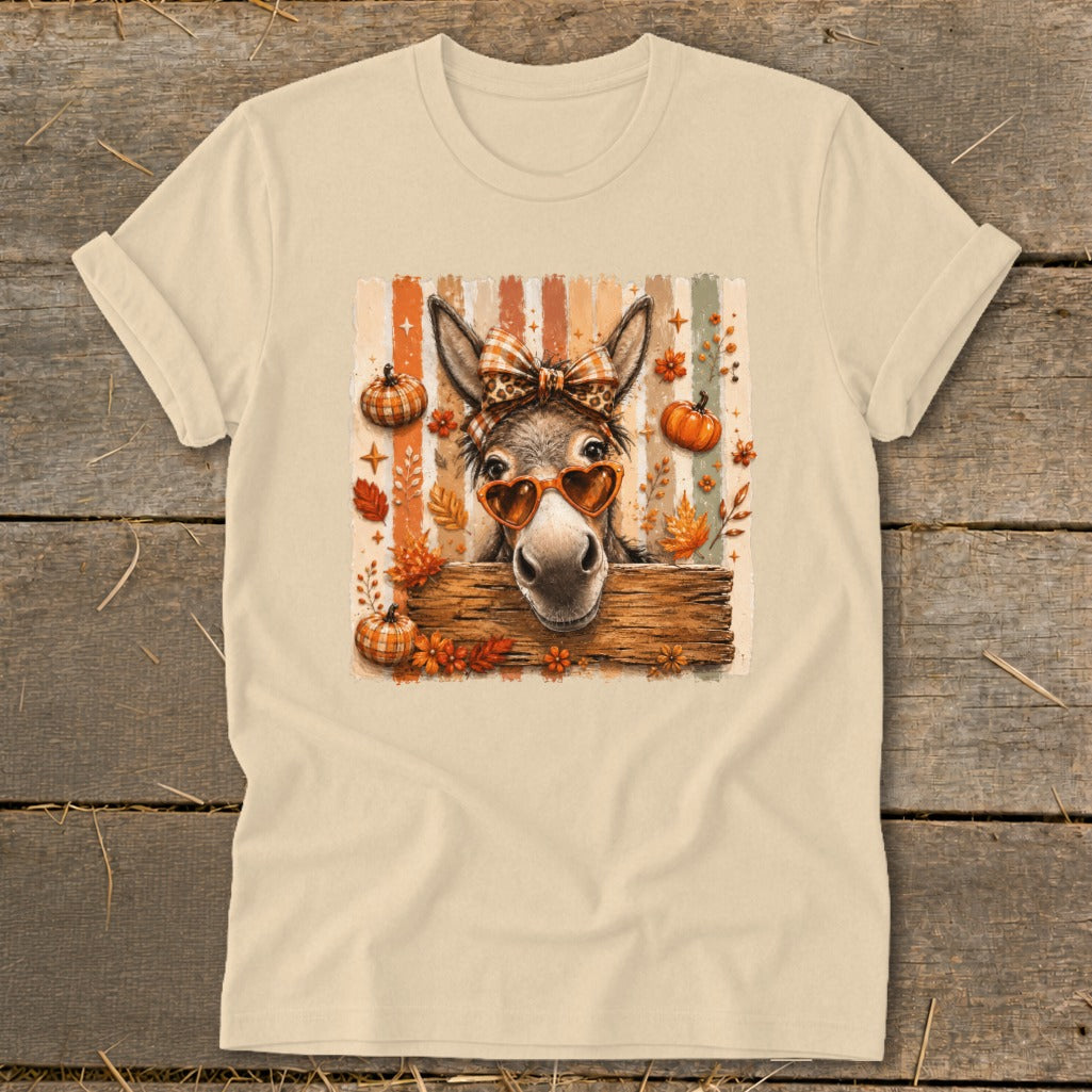 Donkey wearing heart sunglasses and bow, with pumpkins and autumn leaves.