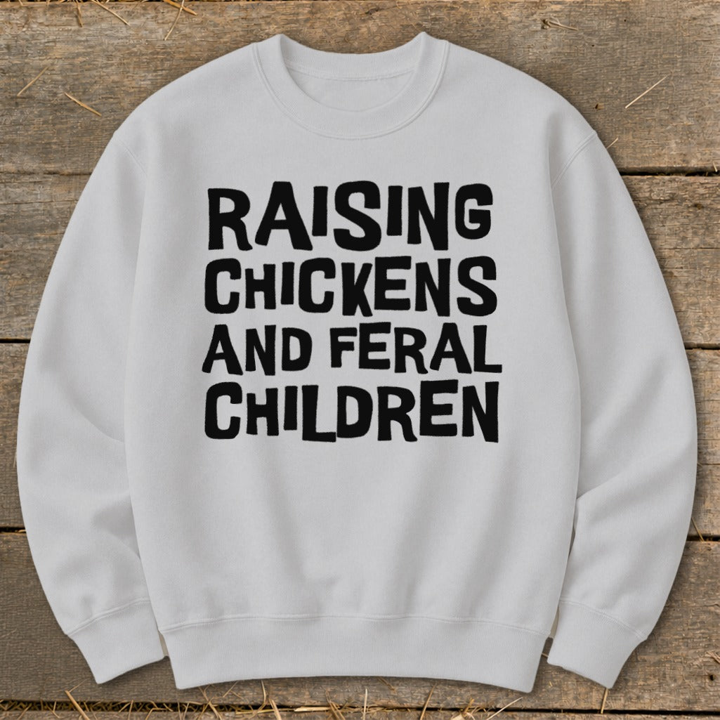 White sweatshirt with black text reading "Raising Chickens and Feral Children".