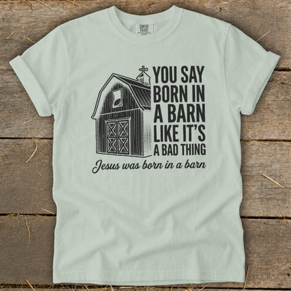 Light green t-shirt with barn graphic and text: "You say born in a barn like it's a bad thing. Jesus was born in a barn."