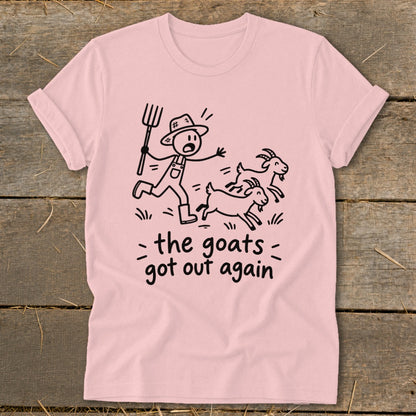 Pink t-shirt with a stick figure farmer chasing three goats, text reads "the goats got out again".