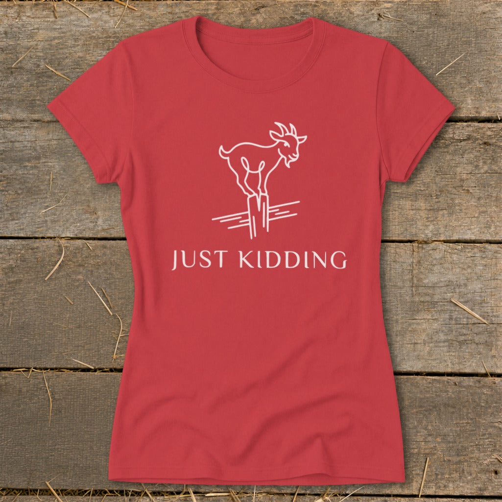 Red t-shirt with white line drawing of a goat standing on posts, text says "JUST KIDDING".