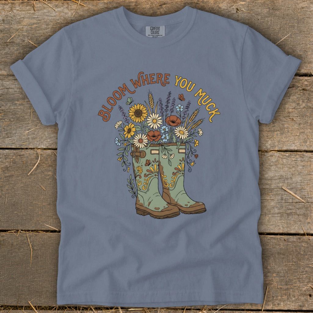 T-shirt with "Bloom Where You Muck" text and gardening boot floral illustration.