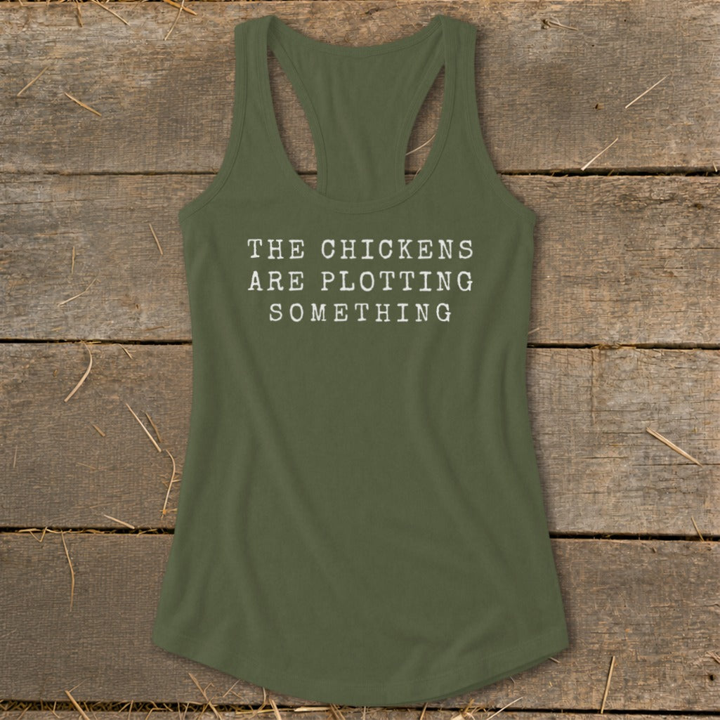 Green tank top with white text reading "THE CHICKENS ARE PLOTTING SOMETHING".
