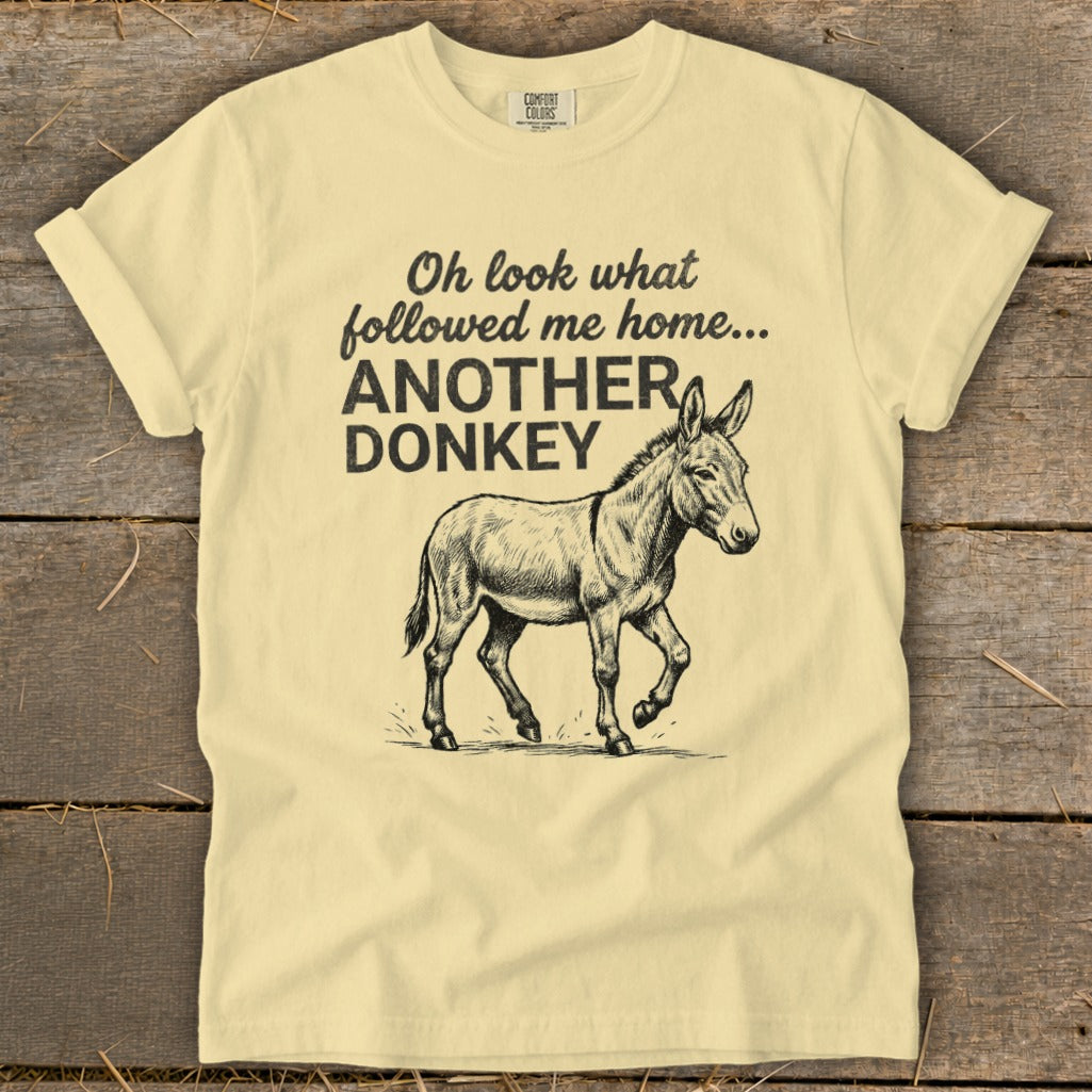 Light yellow t-shirt with sketch of donkey and text: "Oh look what followed me home... ANOTHER DONKEY."
