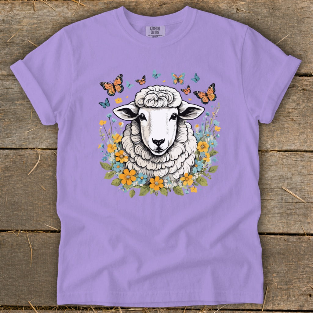 Sheep illustration surrounded by butterflies and colorful flowers on a lavender t-shirt.