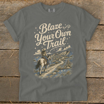 Grey t-shirt with "Blaze Your Own Trail" text and a desert landscape with a person on horseback.