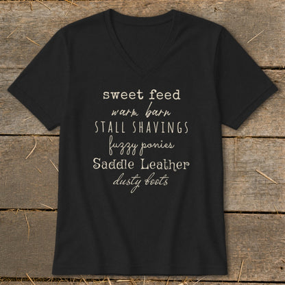 Black t-shirt with "sweet feed warm barn stall shavings fuzzy ponies saddle leather dusty boots" text.