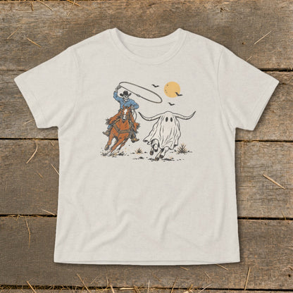 Skeleton cowboy on horseback chasing a longhorn ghost with bats and moon.