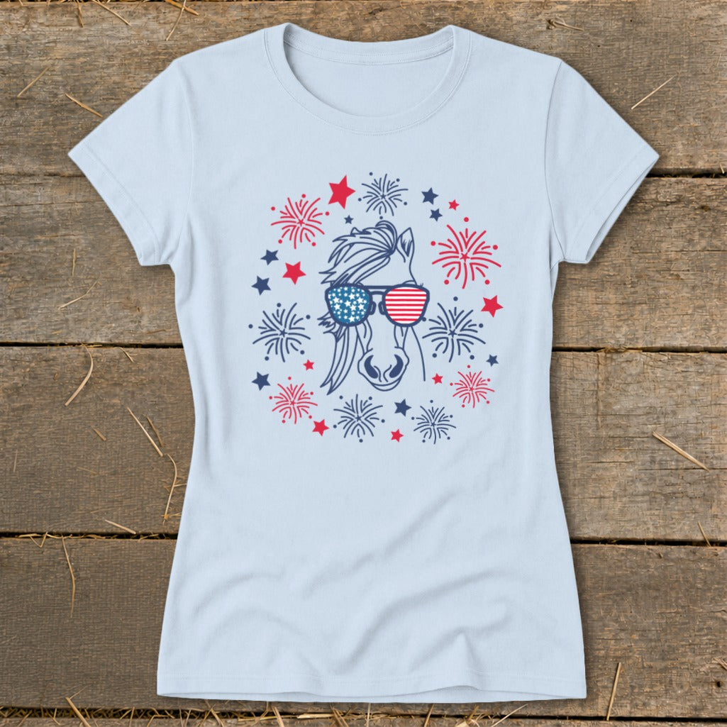 Light blue t-shirt with a horse wearing American flag sunglasses surrounded by fireworks.