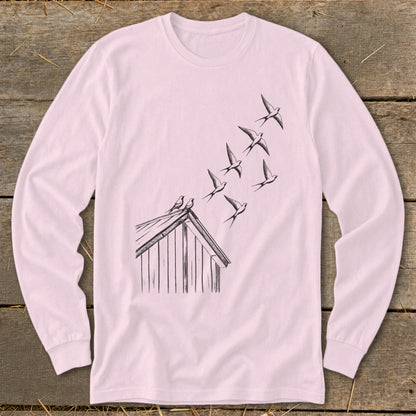 Light pink long-sleeved shirt with a black line art graphic of birds flying from a rooftop.
