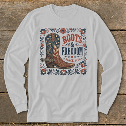White long-sleeve shirt with a distressed graphic of a cowboy boot and "Boots & Freedom Since 1776".