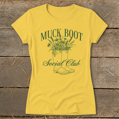 Yellow t-shirt with green "Muck Boot Social Club" text and graphic of boots with flowers.
