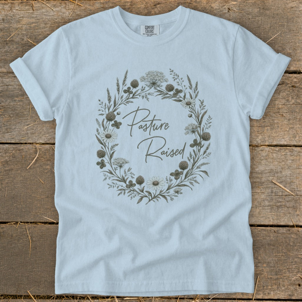 Light blue t-shirt with a floral wreath and "Pasture Raised" text.