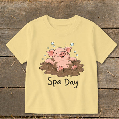 Yellow t-shirt with a cartoon pig enjoying a mud bath with "Spa Day" text.