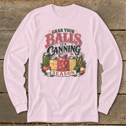 Pink long-sleeve shirt with "Grab Your Balls It's Canning Season" graphic and jars of preserved vegetables.
