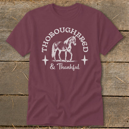 Maroon t-shirt with graphic of a horse, "Thoroughbred & Thankful" text.