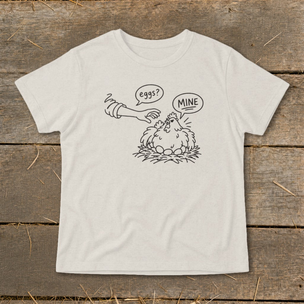 Line drawing on shirt of chicken on nest with eggs and a hand reaching out with text "eggs?" and "MINE".