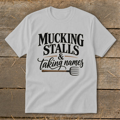 White t-shirt with "Mucking Stalls & Taking Names" and a pitchfork graphic.