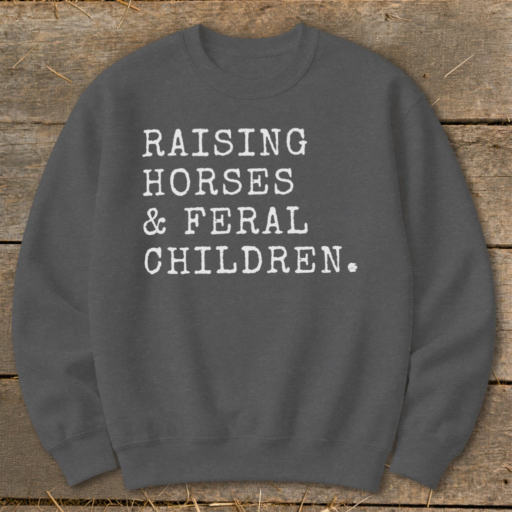 Charcoal crewneck sweatshirt with white text "RAISING HORSES & FERAL CHILDREN."