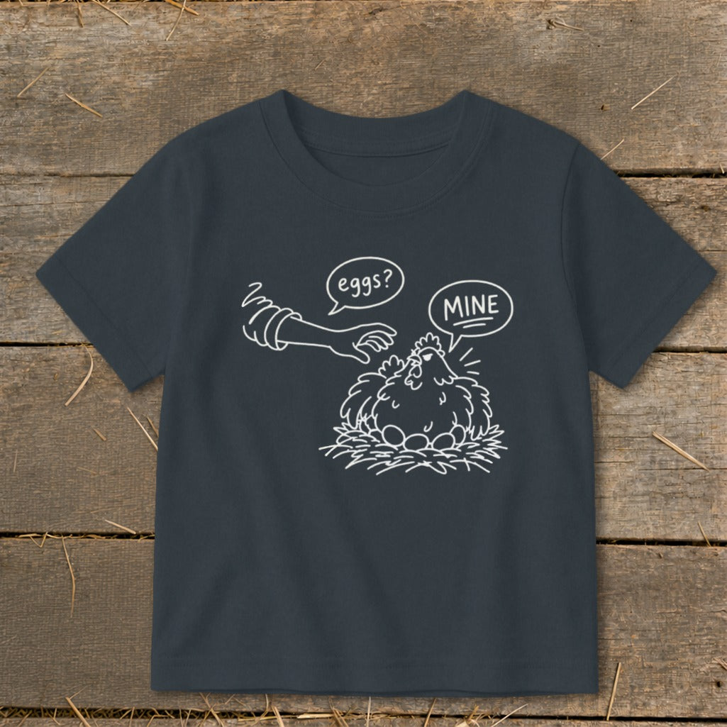 T-shirt with a cartoon of a hen protecting her eggs with text "eggs?" and "MINE".