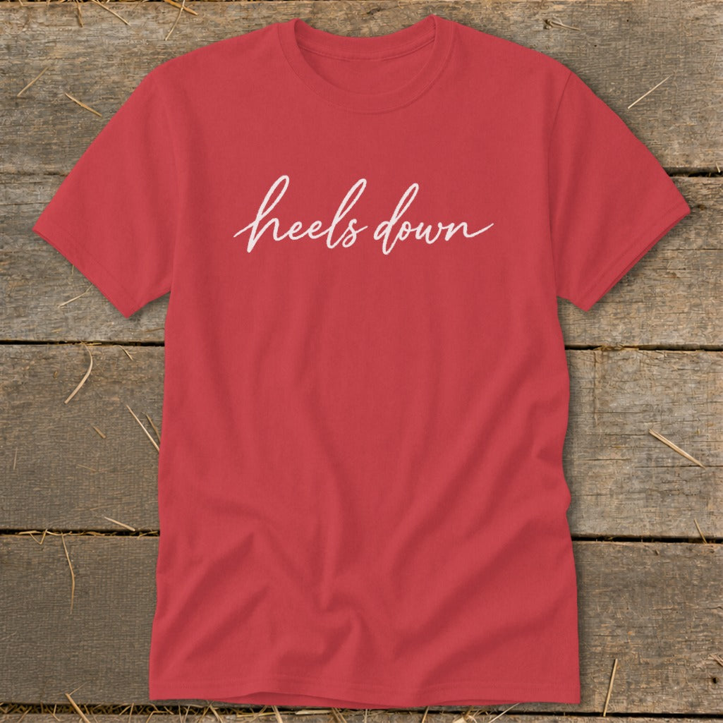 Red t-shirt with white script text that reads "heels down".