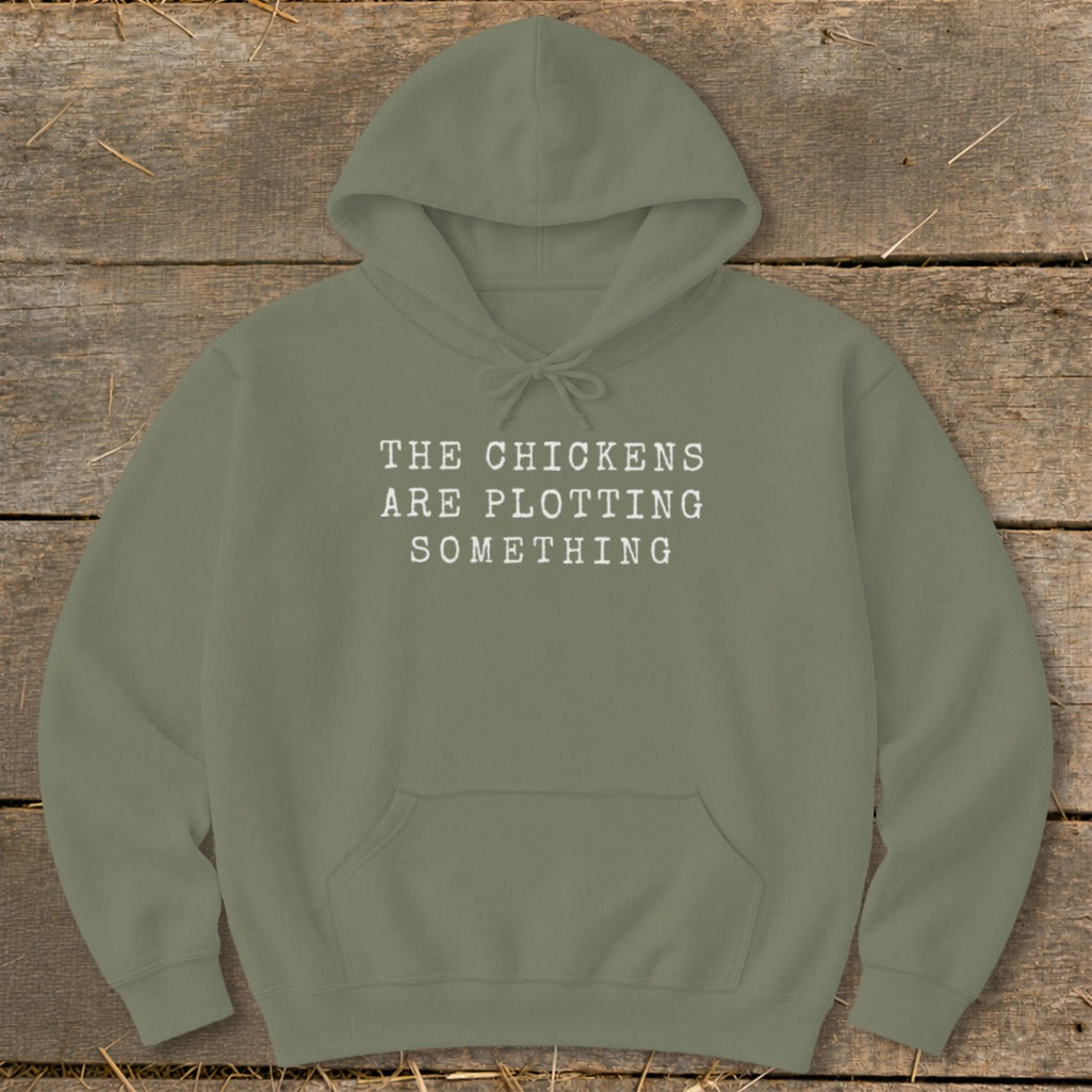 Olive green hoodie with text "THE CHICKENS ARE PLOTTING SOMETHING".