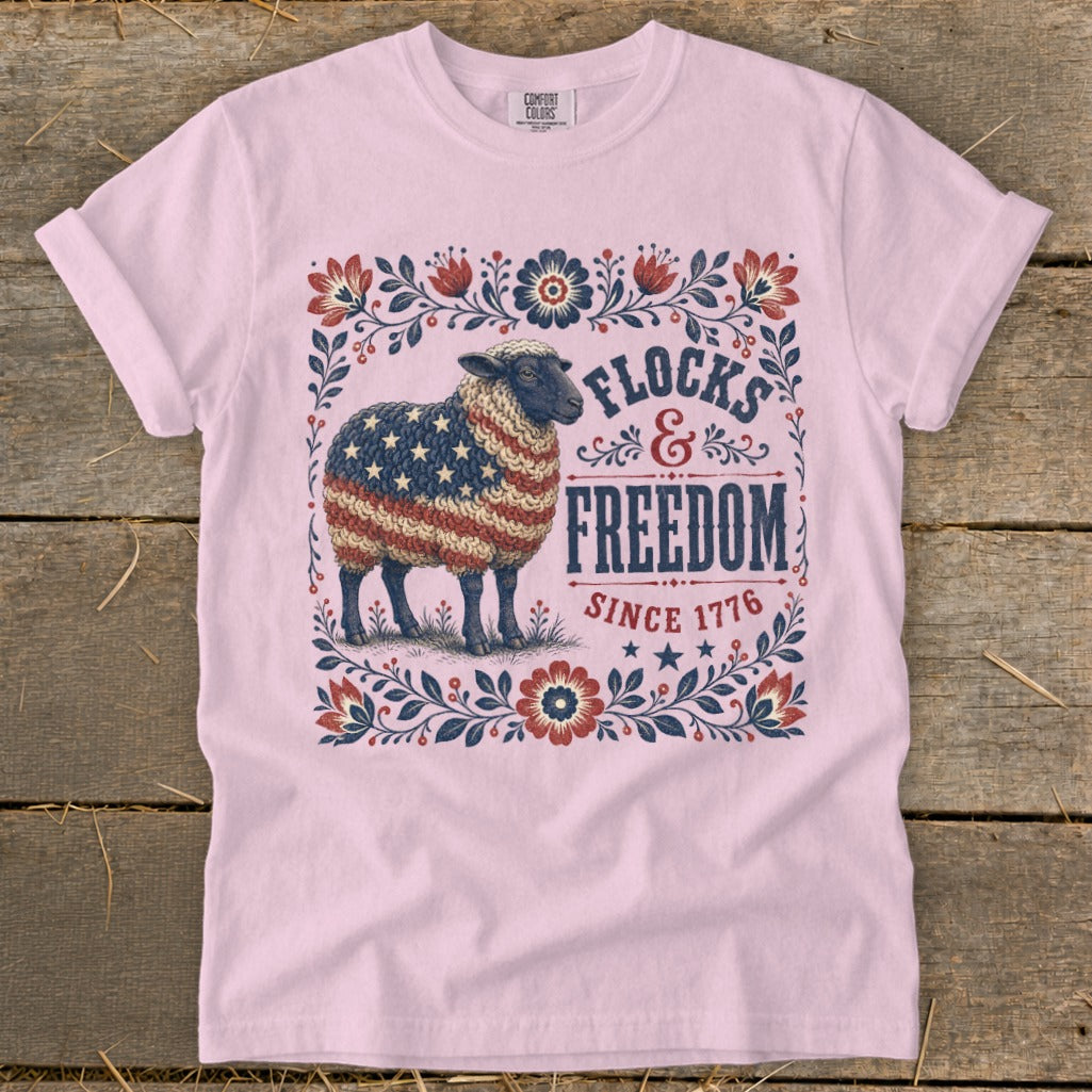 Sheep with American flag pattern on fleece, text "FLOCKS & FREEDOM SINCE 1776"