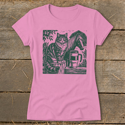 Green linocut of a cat, horse, and coffee mug on a pink t-shirt.