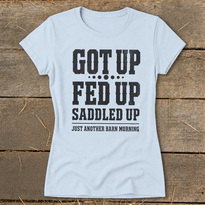 Light blue t-shirt with text "GOT UP FED UP SADDLED UP JUST ANOTHER BARN MORNING"