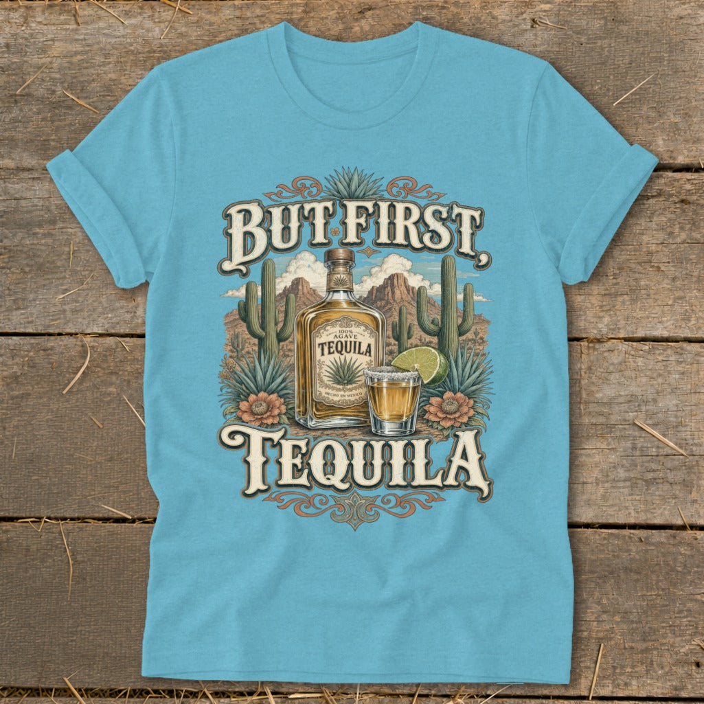 Light blue t-shirt with "But First, Tequila" text, bottle, shot glass, and desert landscape.